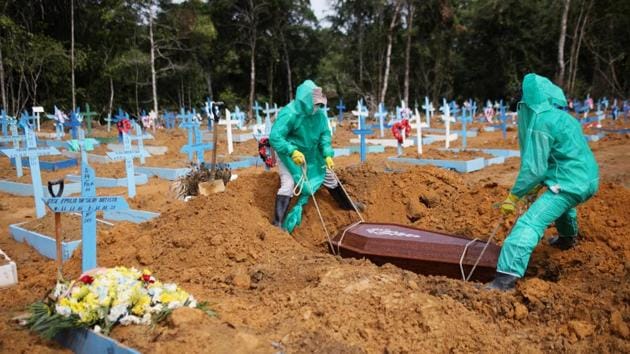 Gravediggers work during the burial of a person who passed away due to the coronavirus in Manaus on June 17. Brazil confirmed its first case of the novel coronavirus on February 26. Nearly four months later, the country is staring at 50,000 deaths --a figure likely to be crossed this weekend. (Bruno Kelly / REUTERS) Gravediggers work during the burial of a person who passed away due to the coronavirus in Manaus on June 17. Brazil confirmed its first case of the novel coronavirus on February 26. Nearly four months later, the country is staring at 50,000 deaths --a figure likely to be crossed this weekend. (Bruno Kelly / REUTERS)