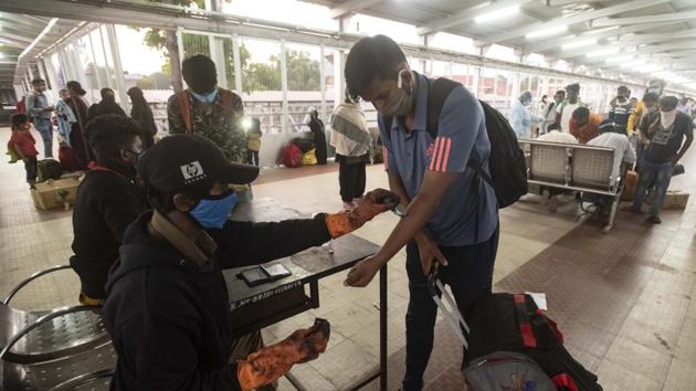 A migrant worker has his forearm marked with a home quarantine stamp at the railway station after arriving from Bihar via a Danapur-Pune Express train in Pune, Maharashtra.(Pratham Gokhale/HT Photo)