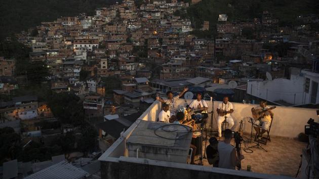 Members of the ‘Tempero de Criola’ band perform a small concert for residents of the Turano favela, in Rio de Janeiro on June 19. Latin America has registered 90,439 deaths to the coronavirus, according to a Reuters tally, with nearly 2 million cases. Brazil alone accounts for over half of both figures. (Silvia Izquierdo / AP) Members of the ‘Tempero de Criola’ band perform a small concert for residents of the Turano favela, in Rio de Janeiro on June 19. Latin America has registered 90,439 deaths to the coronavirus, according to a Reuters tally, with nearly 2 million cases. Brazil alone accounts for over half of both figures. (Silvia Izquierdo / AP)