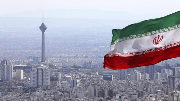 Iran's national flag waves as Milad telecommunications tower and buildings are seen in Tehran, Iran.(AP)