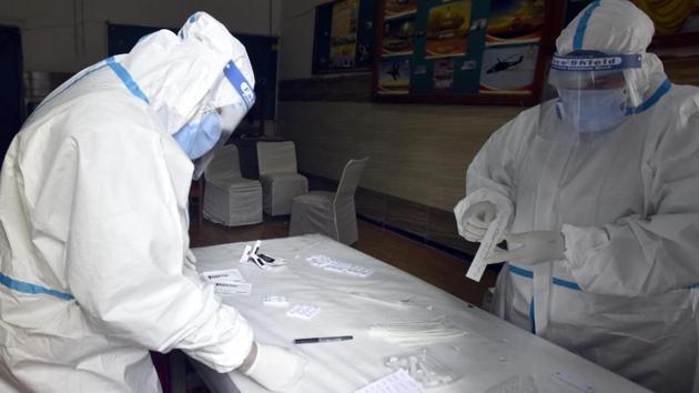 Medical staff collecting swab sample for rapid antigen coronavirus testing at Gandhi Nagar in East Delhi on Sunday.(HT Photo/Sonu Mehta)