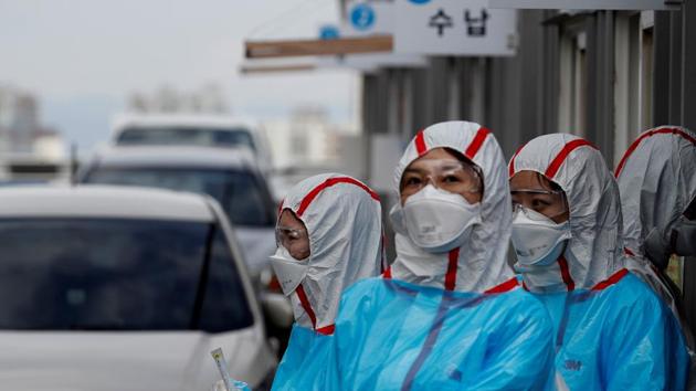 Medical staff in protective gear work at a 'drive-thru' testing center for the novel coronavirus disease of Covid-19 in Yeungnam University Medical Center in Daegu, South Korea.(Reuters Photo)