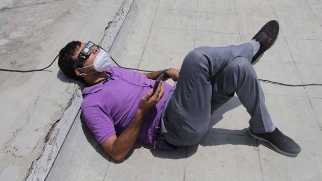 A volunteer at NGO Jyotirvidya Parisanstha lies down as he watched the annular solar eclipse at Kesariwada in Pune on June 21. It is the first solar eclipse of this year taking place on the summer solstice, the longest day in the Northern Hemisphere. (Ravindra Joshi / HT Photo) 