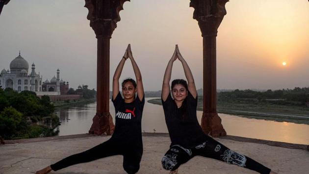 Fitness enthusiasts perform yoga during the sunset on the eve of International Day of Yoga, in Agra.(PTI)