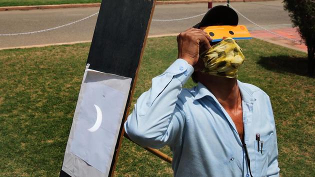 An employee at the Birla Planetarium watches the annular solar eclipse while the Sun’s reflection is caught on a screen next to him, in Jaipur. (Himanshu Vyas / HT Photo) An employee at the Birla Planetarium watches the annular solar eclipse while the Sun’s reflection is caught on a screen next to him, in Jaipur. (Himanshu Vyas / HT Photo)