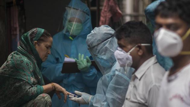 Health care workers check a woman’s blood oxygen levels using a pulse oximeter in Mumbai’s Govandi on June 22. In Mumbai, the focus has shifted to the city’s suburbs to check the rise in the number of Covid-19 cases in areas such as Mulund, Bhandup, Malad, Andheri, Borivli, Kandivli and Dahisar. (Pratik Chorge / HT Photo)