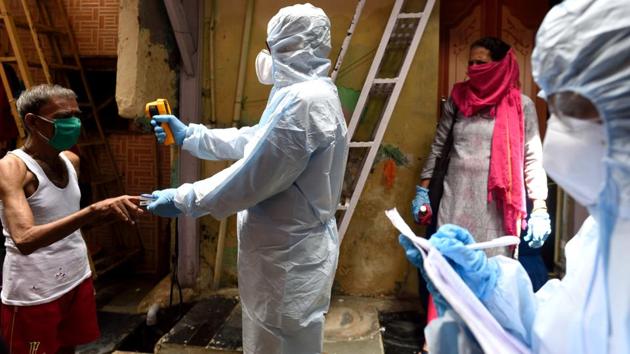 A health care worker checks the temperature of a Dharavi resident in Mumbai on June 20. The number of deaths due to Covid-19 in Maharashtra crossed the 6,000-mark on June 21 with Mumbai alone accounting for 3,671 of the total 6,170 deaths recorded since the coronavirus hit India’s financial capital. (Satish Bate / HT Photo)