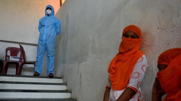A health care worker stands guard at Cheeta Camp, Mankhurd, on June 21. “For the next two weeks, we are concentrating on reducing deaths in the state. We are ready for the rising case load and the health infrastructure has been augmented by the government after the task force insisted upon it,” Dr. Sanjay Oak, who heads the state’s Covid-19 task force, told HT. (Satish Bate / HT Photo)