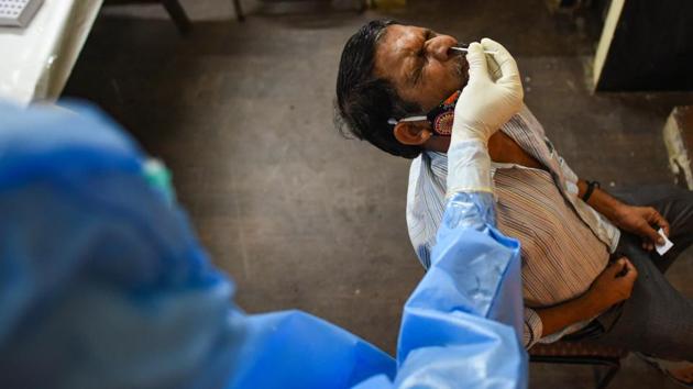 A health worker takes a swab sample for COVID-19 antigen testing in Lado Sarai, New Delhi on June 22. The government has put into effect a revised strategy to contain the outbreak in Delhi and Mumbai, which form the bulk of India’s cases. Union home minister Amit Shah has held several meetings with Delhi CM Arvind Kejriwal over the capital’s Covid response –-the most recent one on June 21. (Amal KS / HT Photo)