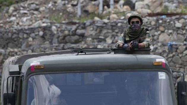 An Indian Army soldier guards atop one of the vehicles as an army convoy moves on the Srinagar- Ladakh highway.(AP photo (Representational image))