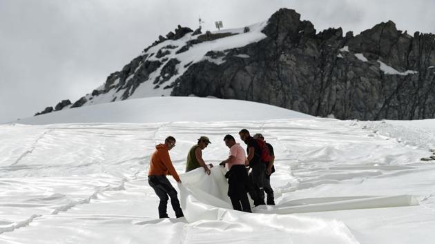 Once the ski season is over and cable cars are berthed, conservationists race to try and stop it melting by using white tarps that block the sun’s rays. “This area is continuously shrinking, so we cover as much of it as possible,” Davide Panizza, who heads the Carosello-Tonale company that does the work, told AFP. (Miguel Medina / AFP) Once the ski season is over and cable cars are berthed, conservationists race to try and stop it melting by using white tarps that block the sun’s rays. “This area is continuously shrinking, so we cover as much of it as possible,” Davide Panizza, who heads the Carosello-Tonale company that does the work, told AFP. (Miguel Medina / AFP)