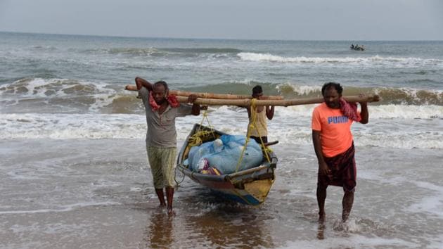 Fishermen pull their boat ashore, during the ongoing COVID-19 nationwide lockdown, in Puri.(PTI) Fishermen pull their boat ashore, during the ongoing COVID-19 nationwide lockdown, in Puri.(PTI)