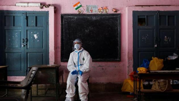 A medical worker sits inside a classroom as she takes a break at a school, which was turned into a centre to conduct tests for the coronavirus disease (COVID-19), amidst its spread in New Delhi. (REUTERS) A medical worker sits inside a classroom as she takes a break at a school, which was turned into a centre to conduct tests for the coronavirus disease (COVID-19), amidst its spread in New Delhi. (REUTERS)