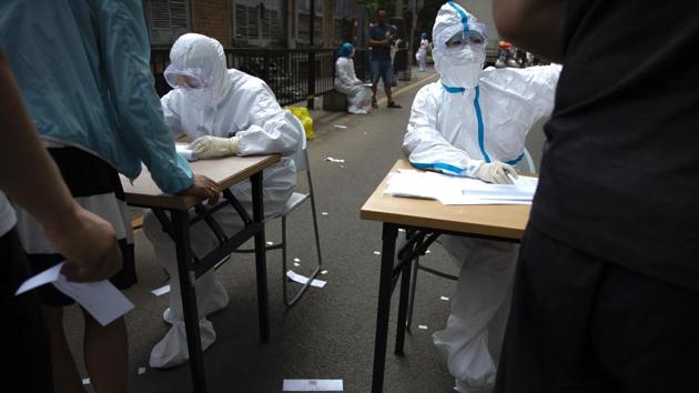 The process began by measuring body temperature, then by checking the Beijing Health Kit app and once the green code on the app indicated “No Abnormal Conditions,” one was ready to be registered for the test. (Mark Schiefelbein / AP) The process began by measuring body temperature, then by checking the Beijing Health Kit app and once the green code on the app indicated “No Abnormal Conditions,” one was ready to be registered for the test. (Mark Schiefelbein / AP)