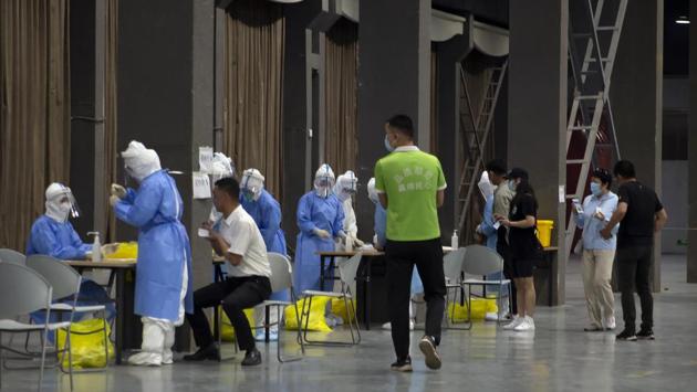 “I was handed a bar-coded vial and waved into a large hall, where a half-dozen tables were set up with a pair of workers in protective suits at each one,” said Mark Schiefelbein. (Mark Schiefelbein / AP) “I was handed a bar-coded vial and waved into a large hall, where a half-dozen tables were set up with a pair of workers in protective suits at each one,” said Mark Schiefelbein. (Mark Schiefelbein / AP)