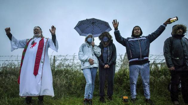 Arthur Uther Pendragon, left, and visitors turn to face the direction of the rising sun next to the closed Stonehenge as people gather to celebrate the dawn of the longest day of the year, the Summer Solstice, near Salisbury, England, Sunday June 21, 2020. (Ben Birchall/PA via AP) Arthur Uther Pendragon, left, and visitors turn to face the direction of the rising sun next to the closed Stonehenge as people gather to celebrate the dawn of the longest day of the year, the Summer Solstice, near Salisbury, England, Sunday June 21, 2020. (Ben Birchall/PA via AP)