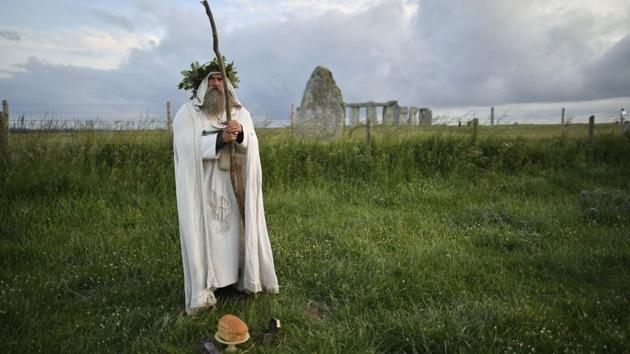 An Archdruid performs a ritual near to the cordoned off Stonehenge as a small group of people gathered to celebrate the Summer Solstice, the longest day of the year, near Salisbury, England, Sunday, June 21, 2020. The coronavirus pandemic has prevented druids, pagans and partygoers from watching the sun rise at Stonehenge to mark the summer solstice. The ancient stone circle usually draws thousands of people to mark the longest day of the year in the northern hemisphere. But Britain has banned mass gatherings as part of measures to contain the spread of COVID-19. English Heritage, the body that oversees Stonehenge, livestreamed the sunrise instead. (Ben Birchall/PA via AP) An Archdruid performs a ritual near to the cordoned off Stonehenge as a small group of people gathered to celebrate the Summer Solstice, the longest day of the year, near Salisbury, England, Sunday, June 21, 2020. The coronavirus pandemic has prevented druids, pagans and partygoers from watching the sun rise at Stonehenge to mark the summer solstice. The ancient stone circle usually draws thousands of people to mark the longest day of the year in the northern hemisphere. But Britain has banned mass gatherings as part of measures to contain the spread of COVID-19. English Heritage, the body that oversees Stonehenge, livestreamed the sunrise instead. (Ben Birchall/PA via AP)