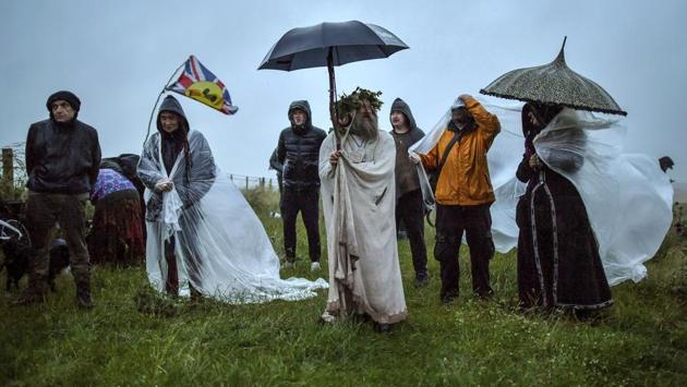 People gather as some shield from the rain next to the closed Stonehenge, to celebrate the Summer Solstice, the longest day of the year, near Salisbury, England, Sunday June 21, 2020. (Ben Birchall/PA via AP) People gather as some shield from the rain next to the closed Stonehenge, to celebrate the Summer Solstice, the longest day of the year, near Salisbury, England, Sunday June 21, 2020. (Ben Birchall/PA via AP)
