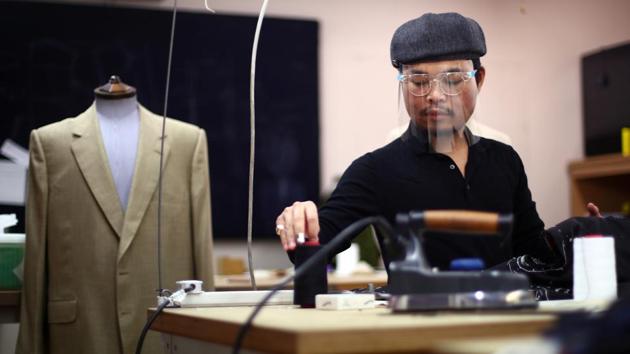 Saville Row Academy student Sam Rithsak Seng makes adjustments to a bespoke jacket at Maurice Sedwell tailors on Saville Row, as the business reopens after an extended lockdown due to the spread of the coronavirus disease (COVID-19) in London, Britain. (REUTERS/Hannah McKay)