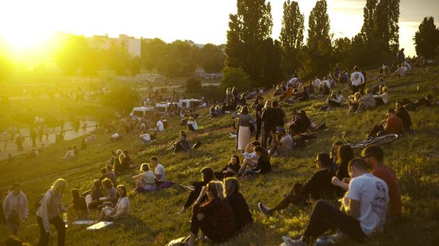 People sit outside as the sun sets on Summer Solstice, the longest day of the year at the public park Mauerpark in Berlin, Germany, Sunday, June 21, 2020. (AP Photo/Markus Schreiber) People sit outside as the sun sets on Summer Solstice, the longest day of the year at the public park Mauerpark in Berlin, Germany, Sunday, June 21, 2020. (AP Photo/Markus Schreiber)