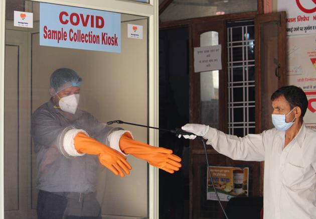 A health worker getting his gloves sanitised during Covid-19 infection testing at Primary Health Centre (PHC) in Gandhi Nagar, Gurugram, on Tuesday. (Yogendra Kumar/HT PHOTO) A health worker getting his gloves sanitised during Covid-19 infection testing at Primary Health Centre (PHC) in Gandhi Nagar, Gurugram, on Tuesday. (Yogendra Kumar/HT PHOTO)