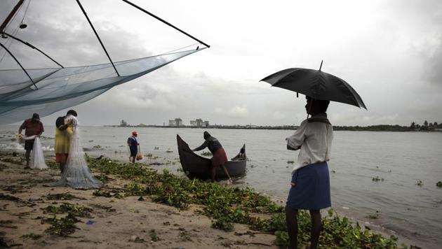 File photo: A man holding an umbrella watches fishermen at work on the Arabian sea coast during monsoon rains in Kochi, Kerala. (AP) File photo: A man holding an umbrella watches fishermen at work on the Arabian sea coast during monsoon rains in Kochi, Kerala. (AP)