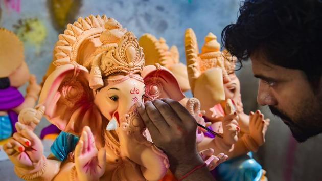 An artist gives final touches to an idol of Lord Ganesh.(PTI)