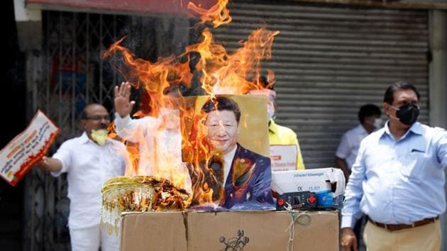 Demonstrators burn products made in China and a defaced poster of Chinese President Xi Jinping during a protest against China, in New Delhi.(REUTERS)
