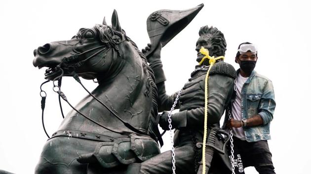 A protestors wraps chains and ropes around the statue of former US President Andrew Jackson during an attempt to pull the statue down in the middle of Lafayette Park in front of the White House. (REUTERS) A protestors wraps chains and ropes around the statue of former US President Andrew Jackson during an attempt to pull the statue down in the middle of Lafayette Park in front of the White House. (REUTERS)