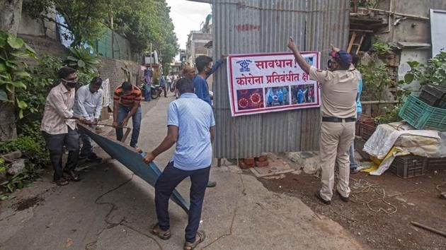 Pune Municipal Corporation (PMC) workers install tin barriers to cordon off a slum area that has been declared a containment zone, in Kothrud, Pune, Maharashtra, India, on Saturday, June 20, 2020. (Pratham Gokhale/HT Photo) Pune Municipal Corporation (PMC) workers install tin barriers to cordon off a slum area that has been declared a containment zone, in Kothrud, Pune, Maharashtra, India, on Saturday, June 20, 2020. (Pratham Gokhale/HT Photo)