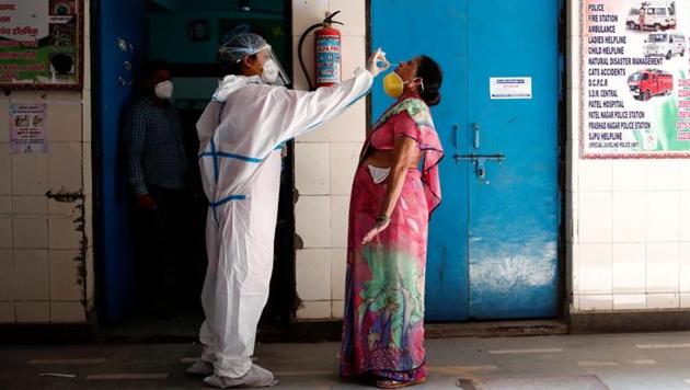 A medical worker collects a sample from a woman at a school turned into a centre to conduct tests for the coronavirus disease (Covid-19), amidst its spread in New Delhi, India June 22, 2020.(Reuters photo) A medical worker collects a sample from a woman at a school turned into a centre to conduct tests for the coronavirus disease (Covid-19), amidst its spread in New Delhi, India June 22, 2020.(Reuters photo)