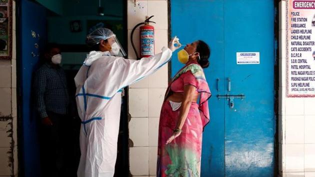 A medical worker collects a sample from a woman at a school turned into a centre to conduct tests for the coronavirus disease (COVID-19), amidst its spread in New Delhi.(REUTERS) A medical worker collects a sample from a woman at a school turned into a centre to conduct tests for the coronavirus disease (COVID-19), amidst its spread in New Delhi.(REUTERS)