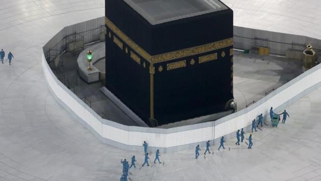 Workers disinfect the ground around the Kaaba, the cubic building at the Grand Mosque, in the Muslim holy city of Mecca, Saudi Arabia after authorities emptied Islam's holiest site for sterilization over fears of the new coronavirus.(AP File Photo)