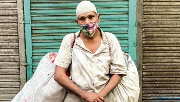 The middle-aged man in shirt and pyjamas is stationed by a pavement in a congested central Delhi market. It is very early in the morning and the shops are still shuttered.(HT photo)