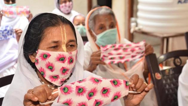 A woman holds a mask stitched by her and her friends at an ashram at Vrindaban.(HT Photos)