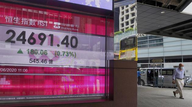 A man wearing a face mask walks past a bank's electronic board showing the Hong Kong share index at Hong Kong Stock Exchange Tuesday. (AP Photo) A man wearing a face mask walks past a bank's electronic board showing the Hong Kong share index at Hong Kong Stock Exchange Tuesday. (AP Photo)
