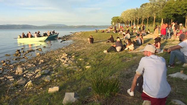 Blues musicians perform on small fishing boats on Lake Trasimeno to ensure social distancing during a concert.(REUTERS)