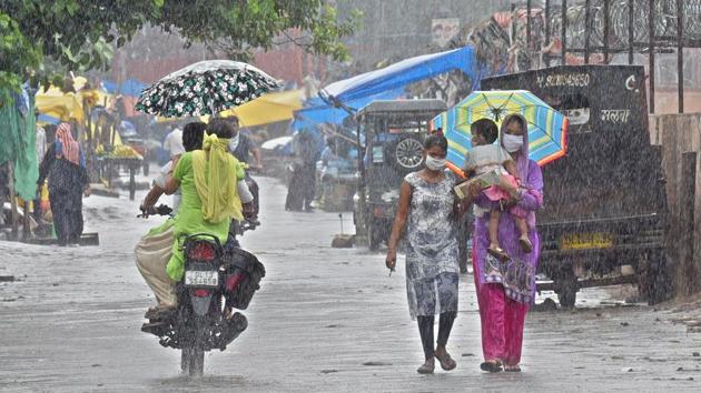 People out with umbrellas during heavy rain in Gandhi Nagar, New Delhi on June 24. IMD said a trough of low pressure is also running from north-western Rajasthan to the north-western Bay of Bengal. These conditions are making it favourable for further advancement of monsoon. (Sonu Mehta / HT Photo)