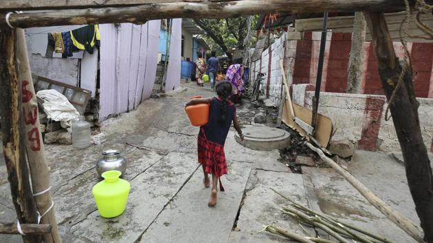 A girl carries a vessel of water near a makeshift barricade set up in a slum during lockdown in Bangalore, India, Tuesday, April 28, 2020. (AP photo for representation) A girl carries a vessel of water near a makeshift barricade set up in a slum during lockdown in Bangalore, India, Tuesday, April 28, 2020. (AP photo for representation)