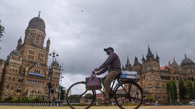 A man rides a bicycle as dark clouds hover over BMC headquarters and CSMT. (PTI) A man rides a bicycle as dark clouds hover over BMC headquarters and CSMT. (PTI)