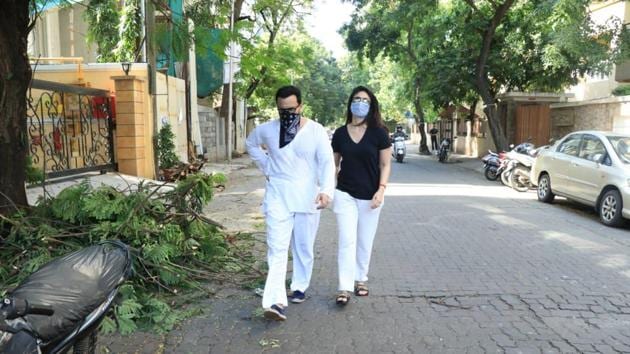 Kareena and Saif walk down the road with masks on. Saif’s is actually a hankerchief covering his face.
