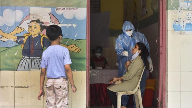 A medical professional collects a swab sample from a woman while a child looks on at SDMC Primary School in Govindpuri, New Delhi on June 24. A sero-survey in the national capital will start from June 27 and will be completed by July 10. Under this survey, 20,000 tests are planned to be done across the city and people of all age groups, reported PTI. (Sanjeev Verma / HT Photo) A medical professional collects a swab sample from a woman while a child looks on at SDMC Primary School in Govindpuri, New Delhi on June 24. A sero-survey in the national capital will start from June 27 and will be completed by July 10. Under this survey, 20,000 tests are planned to be done across the city and people of all age groups, reported PTI. (Sanjeev Verma / HT Photo)