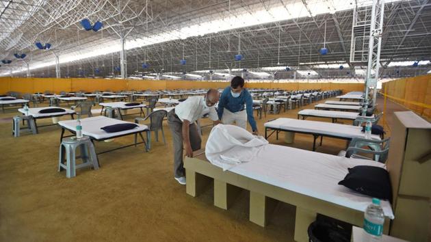 Volunteers make a bed at the Radha Soami Satsang Beas Covid-19 facility on June 24. Relatives of the patients will not be allowed into the centre’s premises for visits during their stay. Patients will be shifted to ICUs or be sent to hospitals if they turn critical while being monitored at the facility. (Ajay Aggarwal /HT Photo) Volunteers make a bed at the Radha Soami Satsang Beas Covid-19 facility on June 24. Relatives of the patients will not be allowed into the centre’s premises for visits during their stay. Patients will be shifted to ICUs or be sent to hospitals if they turn critical while being monitored at the facility. (Ajay Aggarwal /HT Photo)
