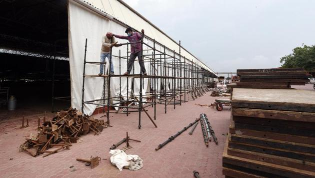 Workers construct scaffolding outside the temporary Covid-19 facility on June 24. For uninterrupted water supply in the centre, the government has installed hydrants for an underground reservoir facility that has a capacity of 1.7 lakh litres. Additionally, MTNL has been asked to provide telecommunications and internet connectivity. (Ajay Aggarwal / HT Photo) Workers construct scaffolding outside the temporary Covid-19 facility on June 24. For uninterrupted water supply in the centre, the government has installed hydrants for an underground reservoir facility that has a capacity of 1.7 lakh litres. Additionally, MTNL has been asked to provide telecommunications and internet connectivity. (Ajay Aggarwal / HT Photo)