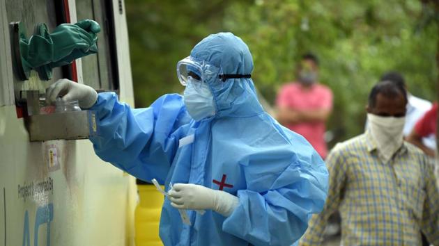 A health worker in a PPE bodysuit handles swab samples collected from police personnel for coronavirus testing. (Parveen Kumar/Hindustan Times) A health worker in a PPE bodysuit handles swab samples collected from police personnel for coronavirus testing. (Parveen Kumar/Hindustan Times)
