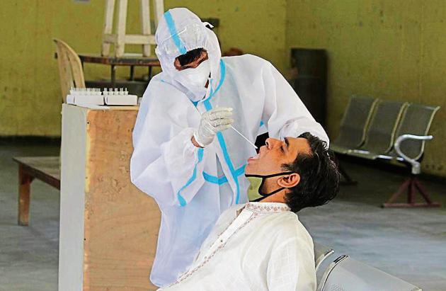 A health worker collects a swab sample from a man for testing at Kadipur Community Centre in Gurugram on Thursday. (Yogendra Kumar/HT PHOTO) A health worker collects a swab sample from a man for testing at Kadipur Community Centre in Gurugram on Thursday. (Yogendra Kumar/HT PHOTO)