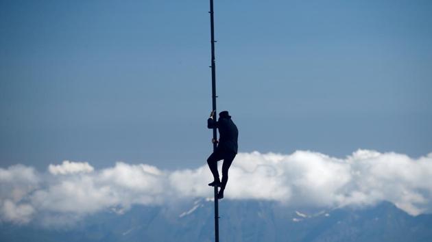 Swiss acrobat Ramon Kathriner performs on a pole during the Airshow, marking the reopening of facilities after the coronavirus disease (COVID-19) lockdown in Les Diablerets, Switzerland, June 23, 2020. (REUTERS/Denis Balibouse)