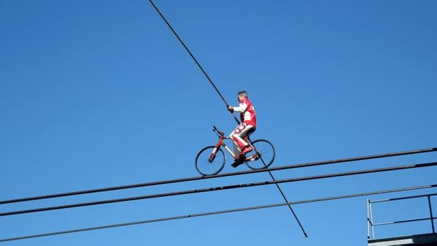 Swiss acrobat Freddy Nock balances on a bicycle on the cable of the Glacier 3000 cable car during the Airshow, marking the reopening of facilities after the coronavirus disease (COVID-19) lockdown in Les Diablerets, Switzerland, June 23, 2020. (REUTERS/Denis Balibouse)