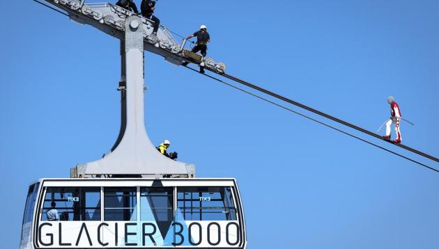Switzerland's tightrope artist Freddy Nock walks on a rope of cable car with a completely opaque helmet during the Glacier 3000 Air Show to draw attention to the dramatic situation in the event industry due to the coronavirus outbreak in the village Les Diablerets of the municipality Ormont-Dessus, Switzerland, Tuesday, June 23, 2020. (Laurent Gillieron/Keystone via AP)