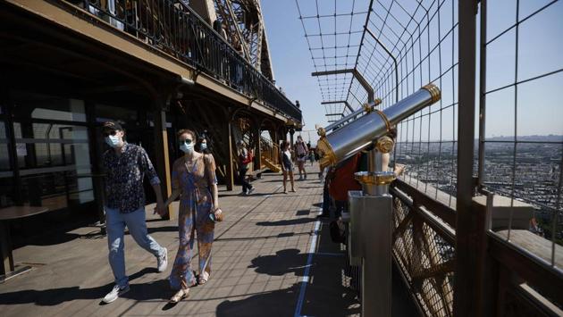 People walk along a viewing platform at the Eiffel Tower on June 25. Visitors are not allowed to go any higher than the second floor of the tower at the moment. (Thomas Samson/ AFP)